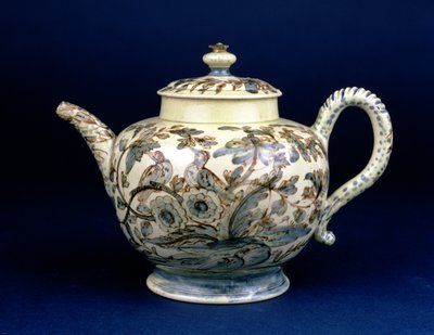 Staffordshire Creamware teapot known as The Tunstall Teapot decorated with three birds in oriental foliage, painted in brownish manganese the outline heightened in blue and green underglaze by F. Morg by English School